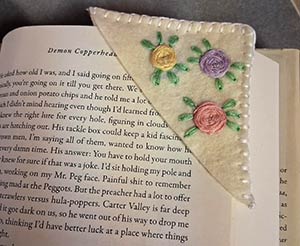 a felt bookmark in the shape of a teacup with a teabag coming from its top