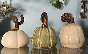 a photo of three pottery pumpkins
