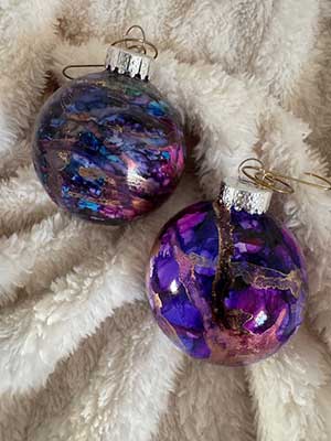 a photo of Christmas ornaments colored by alcohol ink in purple and pink colors