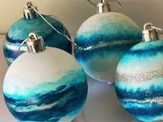 a photo of four holiday ornaments colored by alcohol ink