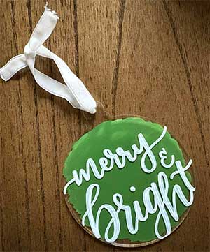 a hand lettered ornament with the message "merry and bright"