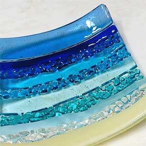 a photo of a  glass dish that has blues and greens similar to water colors