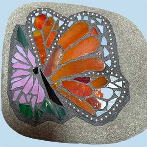 a mosaic rock showing a butterfly and flower