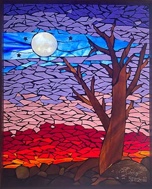 a glass mosaic of a tree, moon and night sky