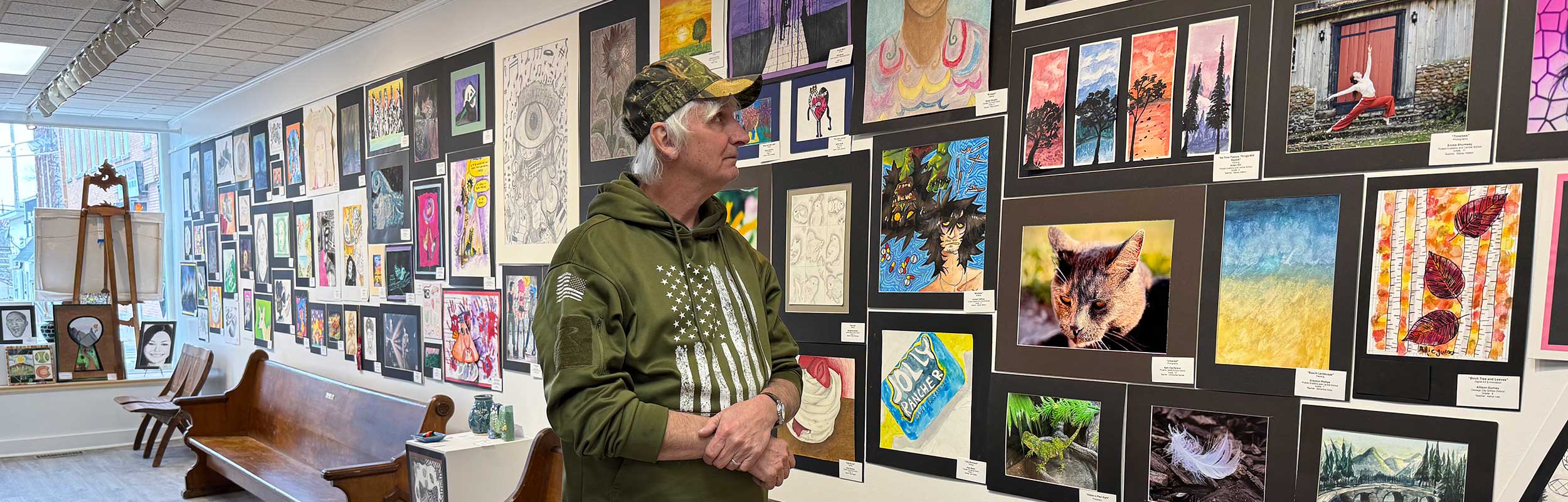 website banner showing some of the student artwork and one person admiring it