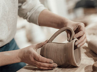 photo of a potter shaping a mug