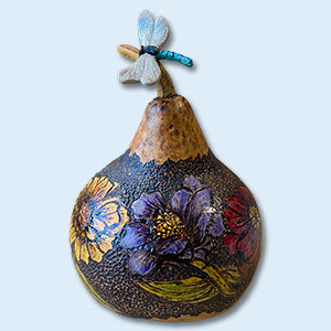 a gourd painted with flowers and topped by a butterfly