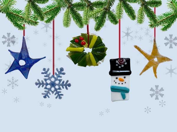 a photo of several handmade ornaments hanging from pine boughs